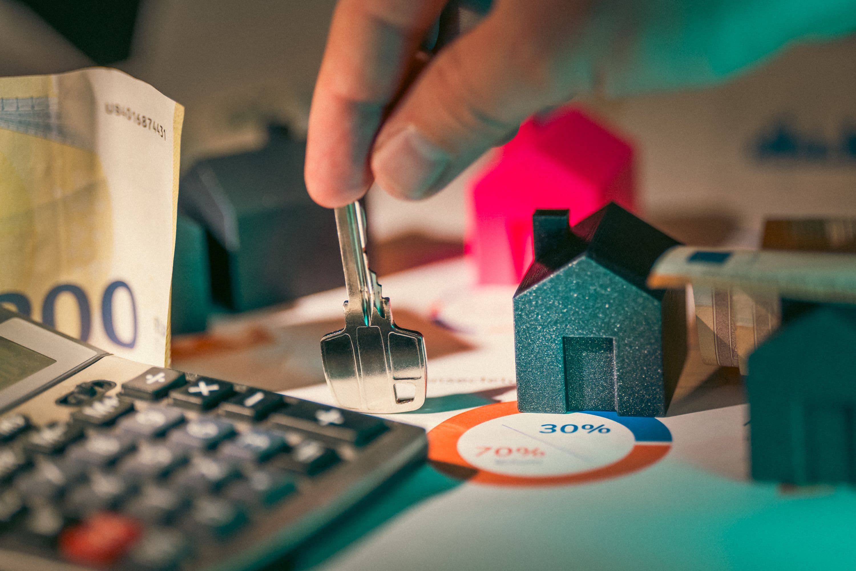 House model and keys beside financial documents